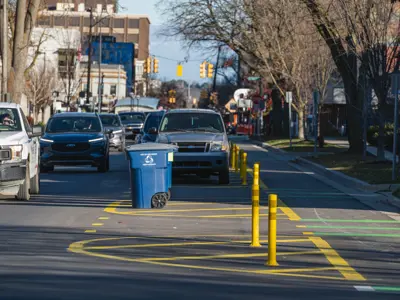 Photo of bike lane inside parking lane; carts go in marked areas of parking lane. 
